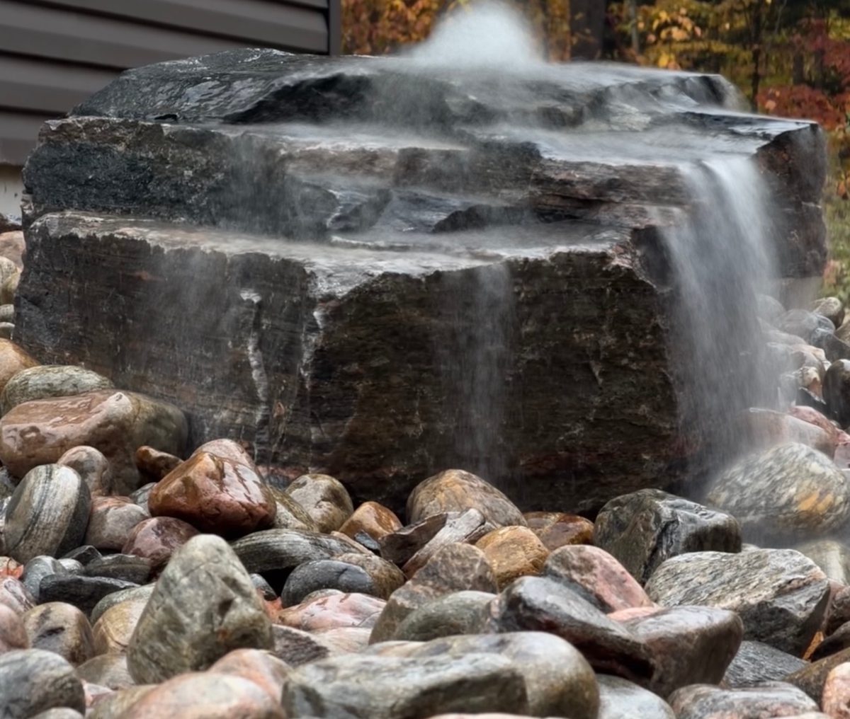 Long exposure of water spilling off a granite boulder onto river rock
